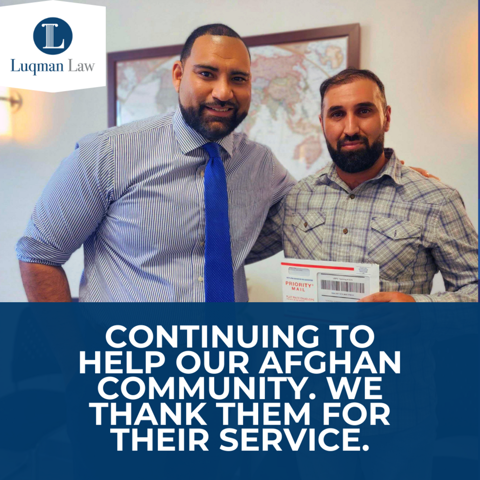 Two men smiling at the camera in an office setting, one wearing a striped shirt and blue tie, and the other in a plaid shirt holding a Priority Mail envelope. A map is visible in the background, and a logo with the text "Luqman Law" is in the top left corner. Text on the image reads "CONTINUING TO HELP OUR AFGHAN COMMUNITY. WE THANK THEM FOR THEIR SERVICE."