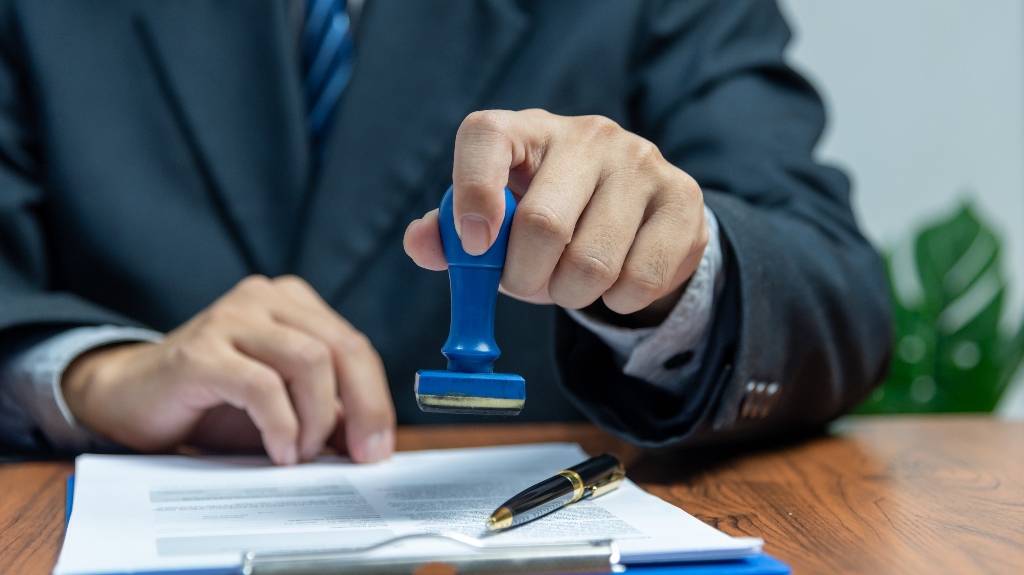 Man is putting stamp on the document